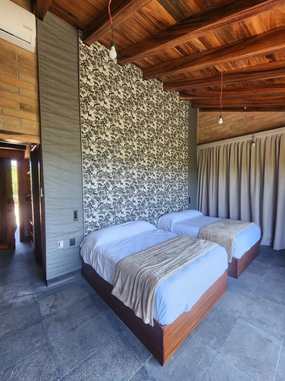 Bases de cama a medida en madera cálida en recámara de cabaña con papel tapiz botánico en Picachos, Mazatlán