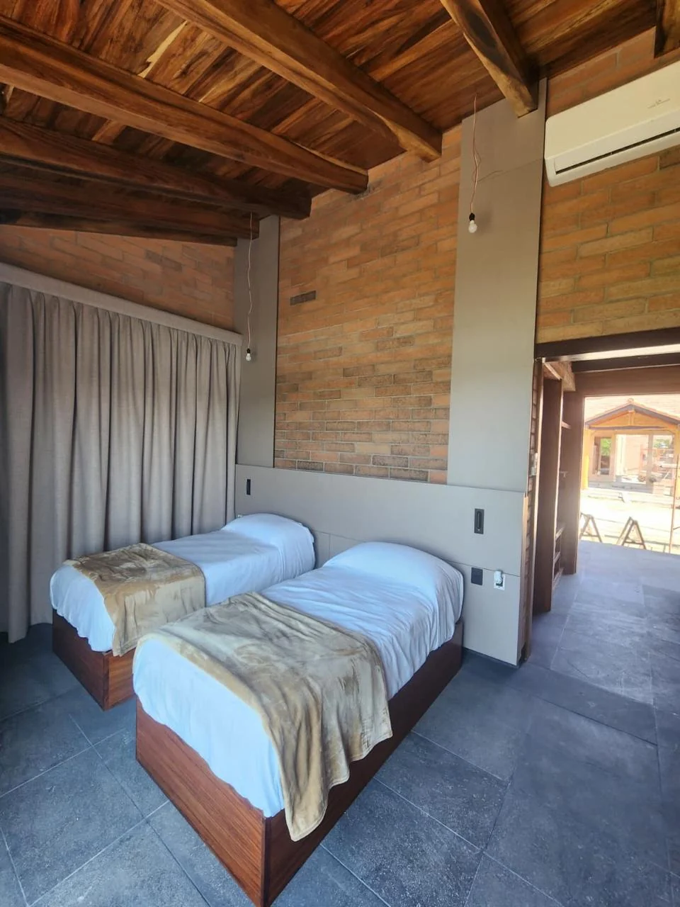 Recámara de cabaña con bases de cama a medida y cabecera tipo panel continuo en Mazatlán