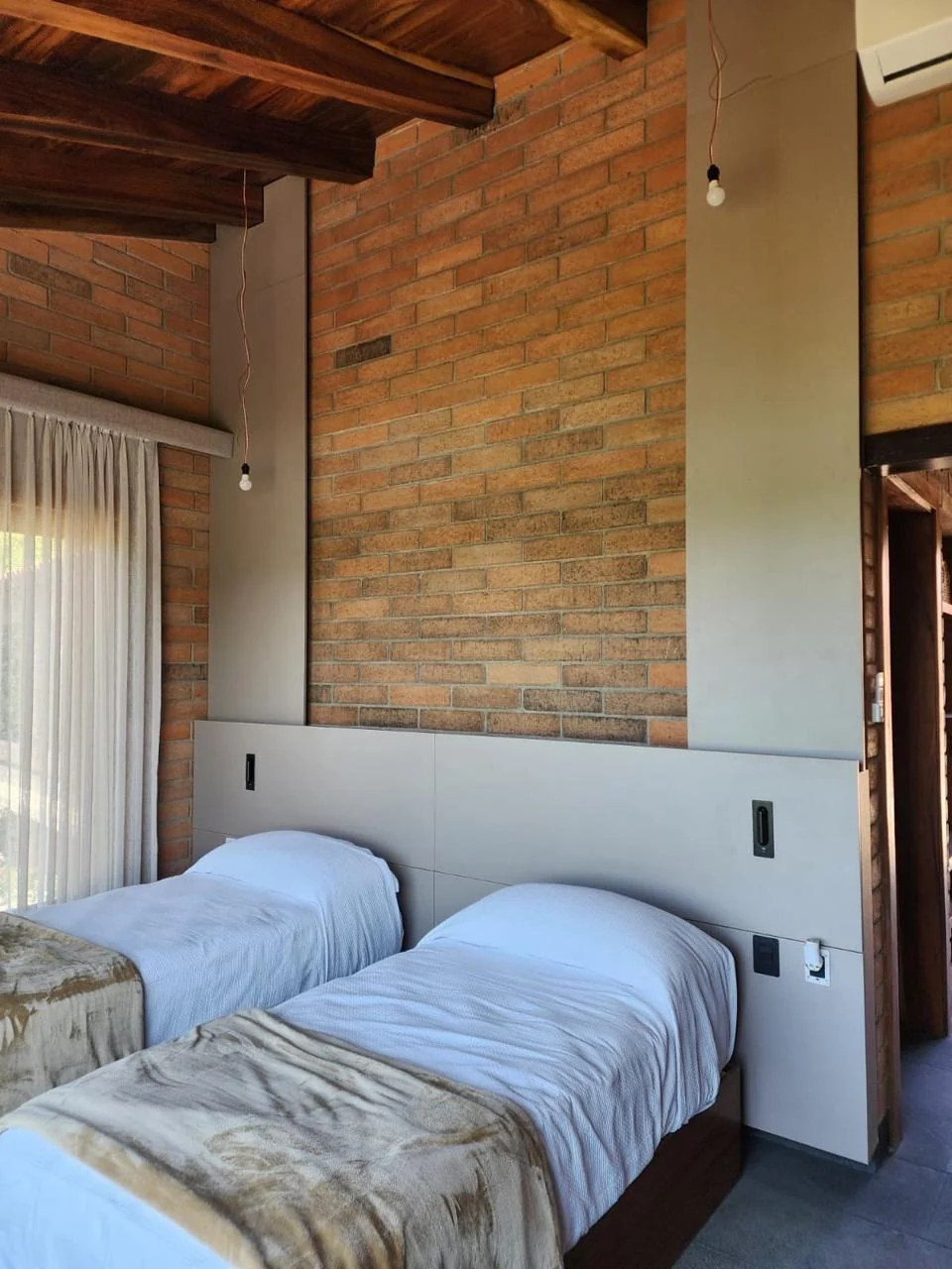 Camas gemelas con bases de madera a medida y cabecera continua en cabaña de Picachos, Mazatlán