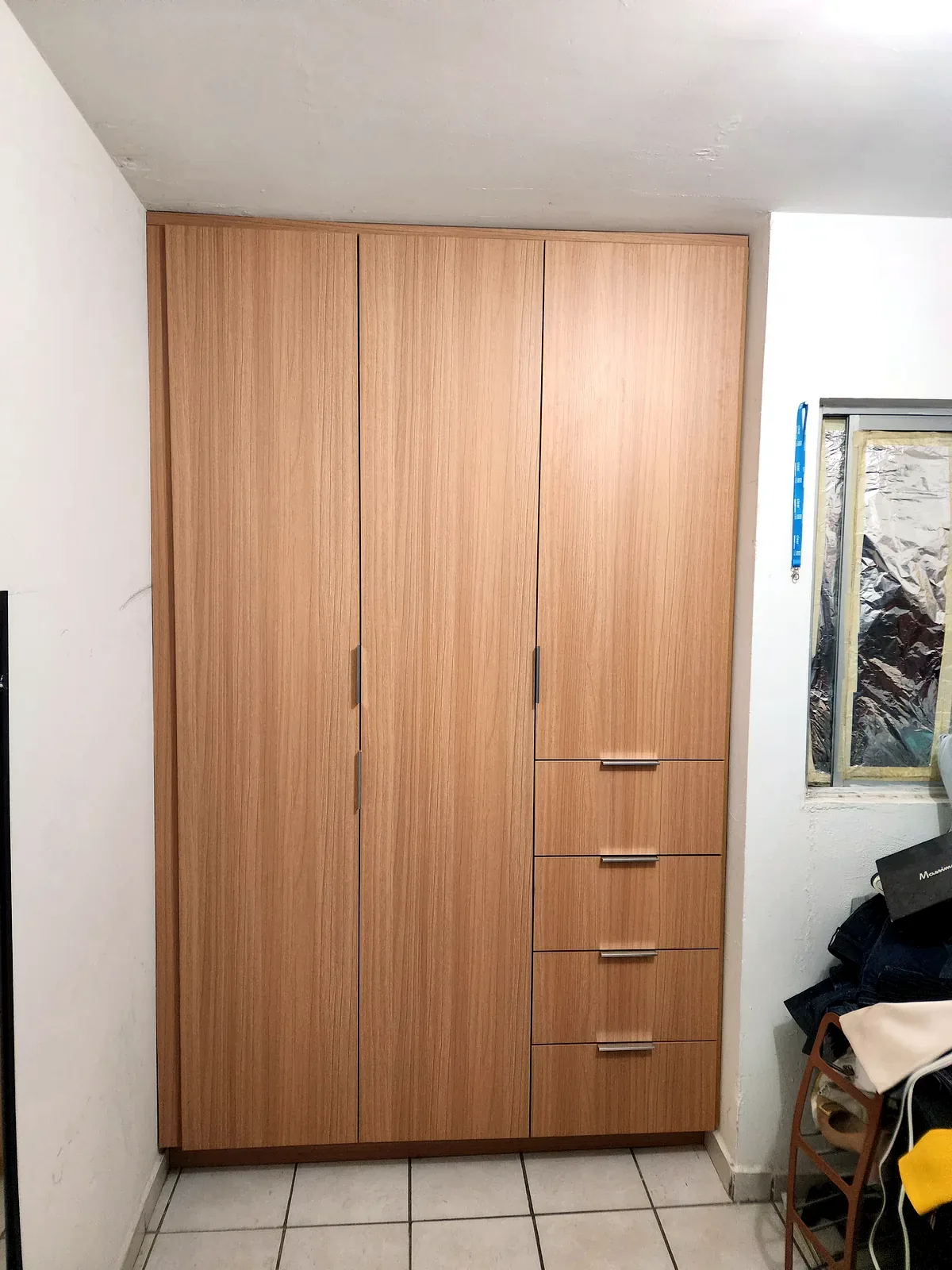 Closet empotrado a medida con puertas abatibles y cajonera lateral en Culiacán