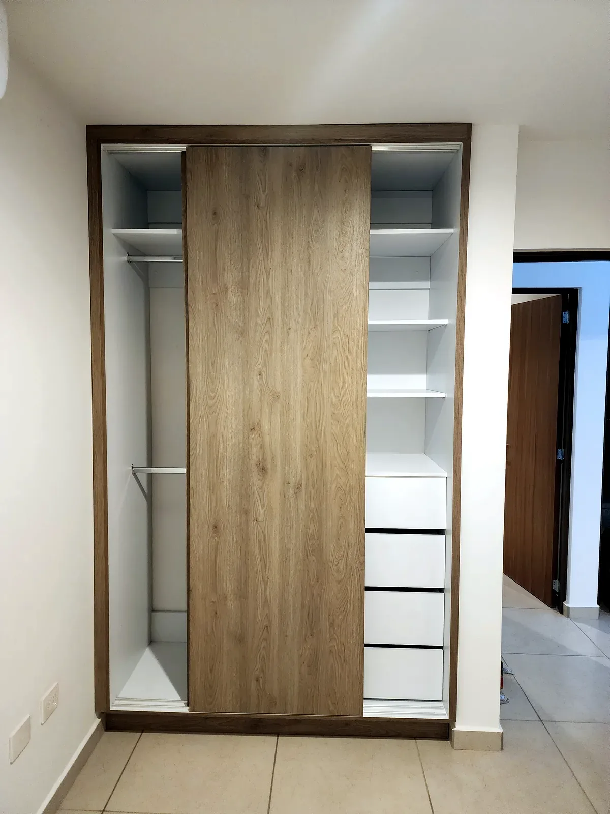 Closet con puertas corredizas, cajoneras y áreas de colgado fabricado por Zeder Cabinets