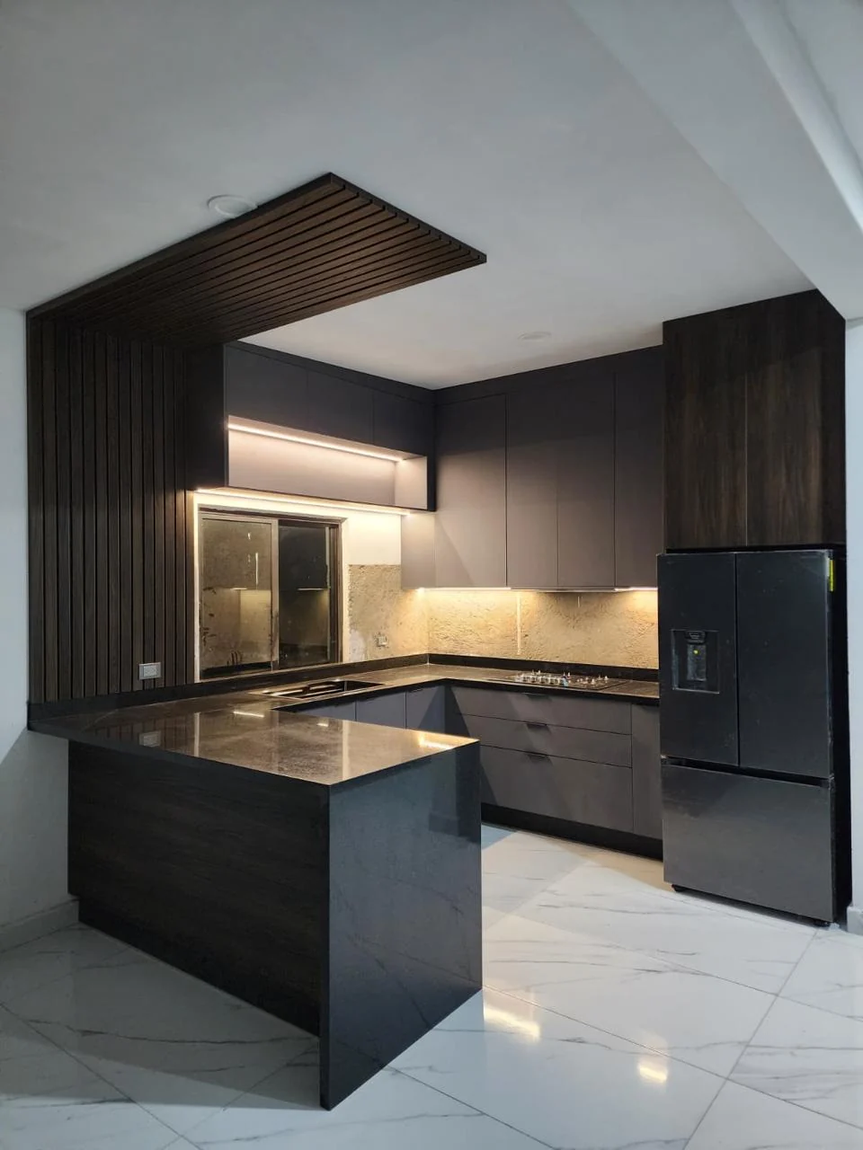 Cocina integral en U con península, frentes grafito mate y panel de listones de madera en Altata, Navolato