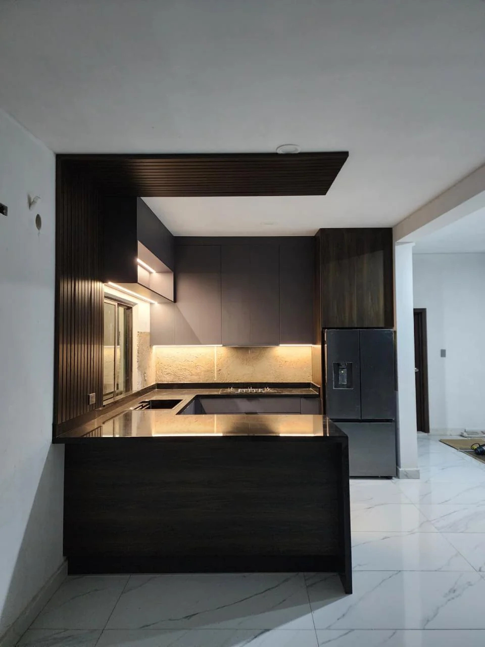 Vista general de cocina a medida en U con plafón de listones e iluminación LED en Altata, Sinaloa