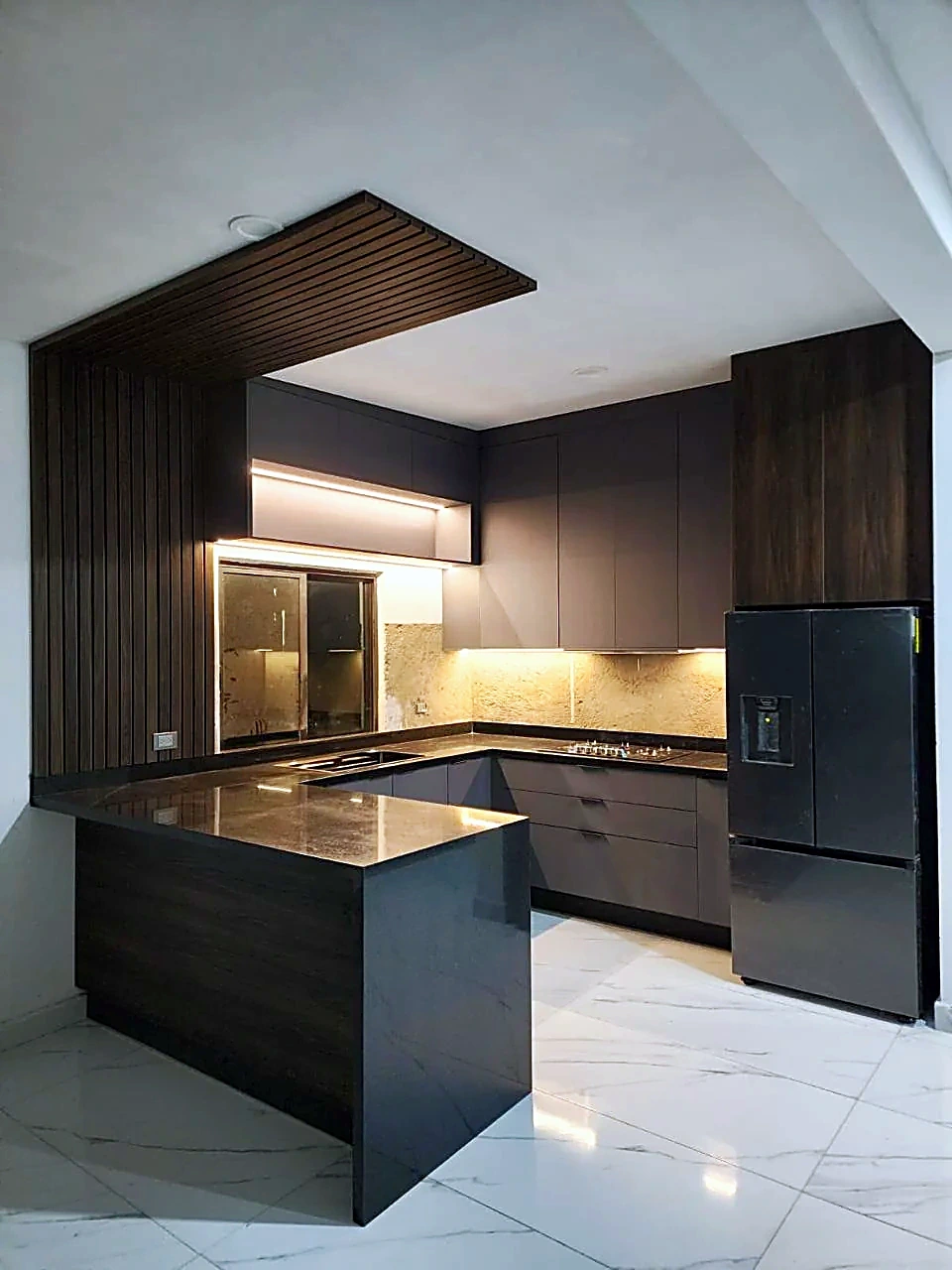 Cocina integral en U con península, frentes grafito mate y panel de listones de madera, fabricada a medida por Zeder en Culiacán, Sinaloa