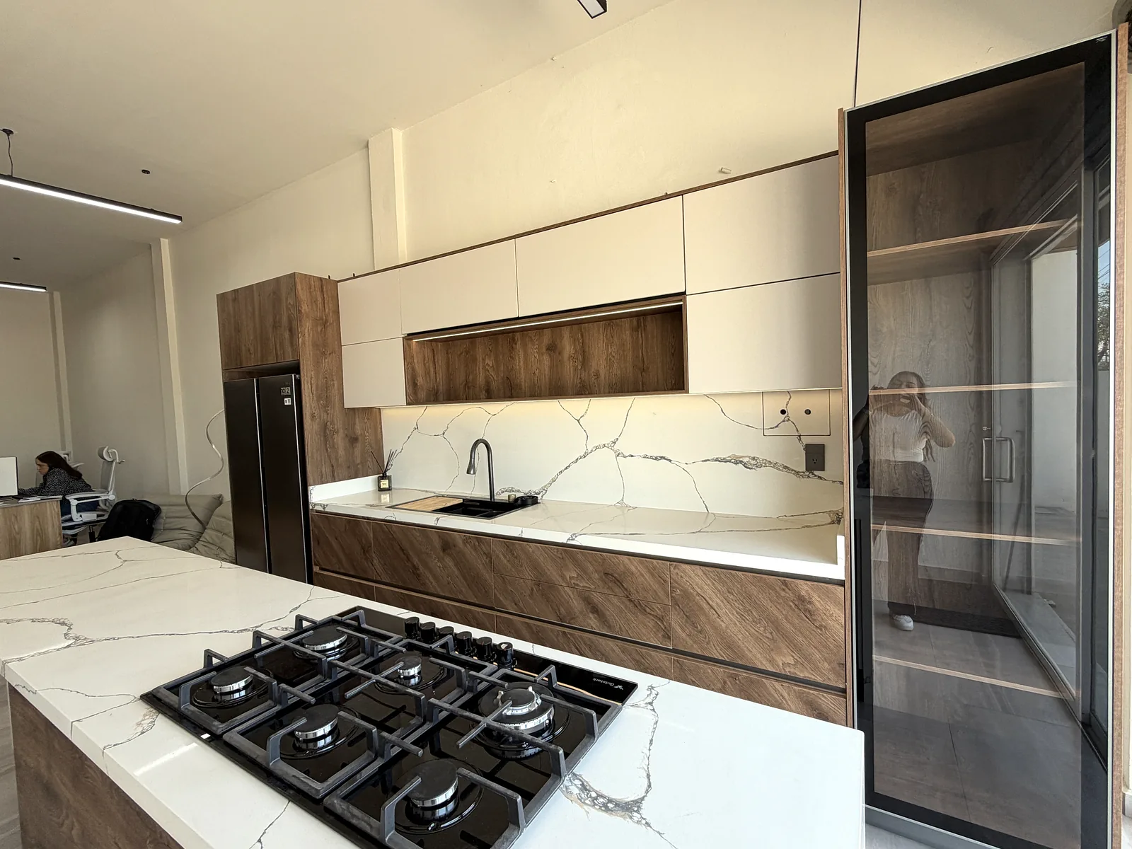 Isla de cocina con parrilla de gas y cubierta de cuarzo en el showroom de Zeder Cabinets, Culiacán